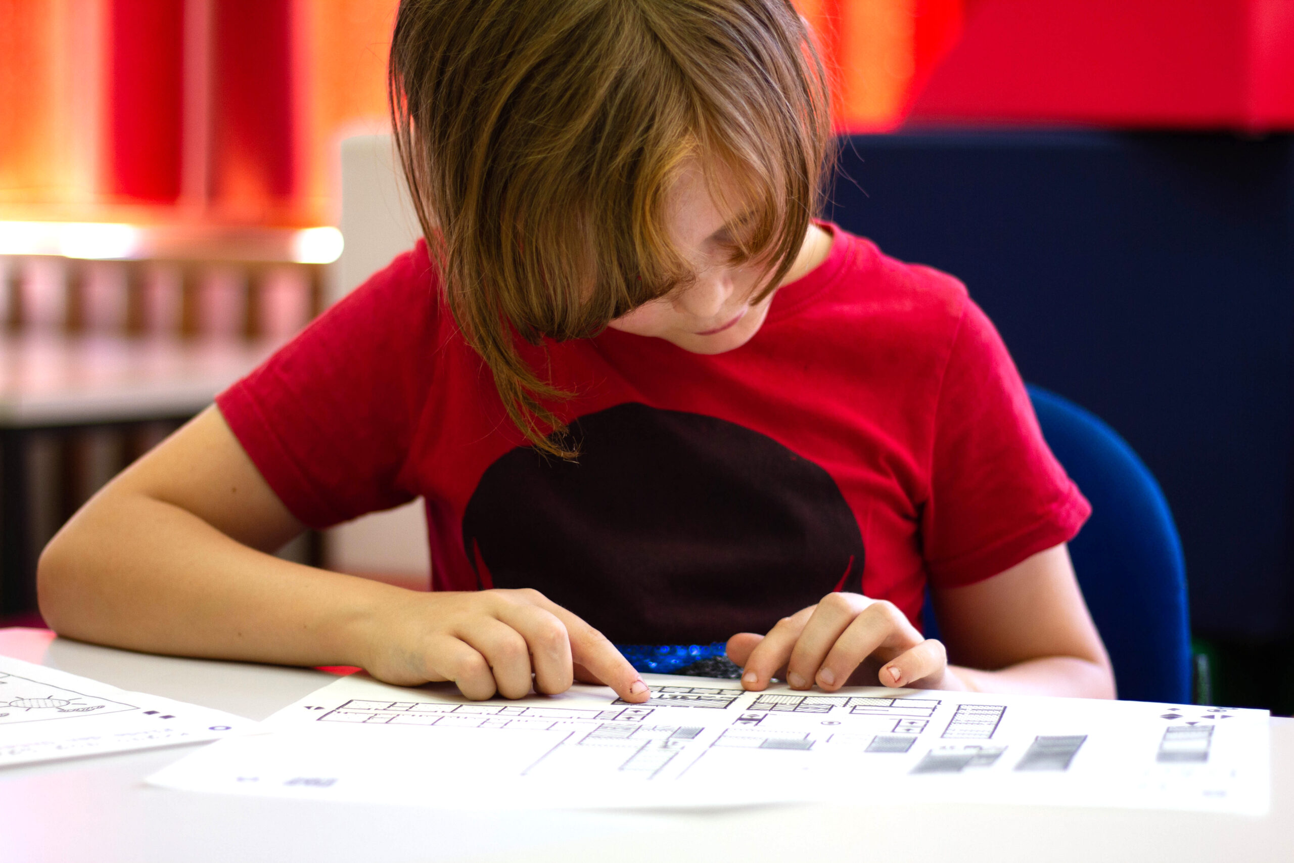 11Der taktile Grundriss einer Schule wird von einem Jungen ertastet. The tactile floor plan of a school is felt by a boy.